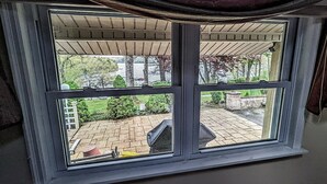 A window with a view of a brick patio and a covered area with a pergola. - Grandview Getaway with a Million Dollar View! (Lakeville)
