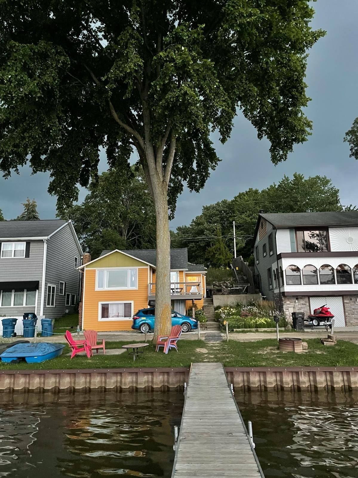 Un quartier résidentiel avec des maisons, un quai et un arbre.