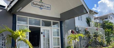 Un edificio con un cartel que dice "BayheightsEscape" y una amplia puerta de cristal de entrada.