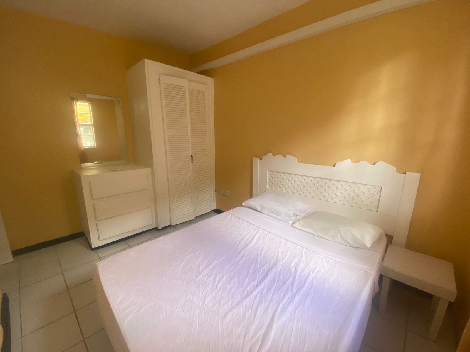 Une chambre à coucher comprenant un lit, une commode, une armoire et une table de chevet.