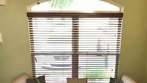 A room with a sofa bed, a window with blinds, and a view of the outside. - Comfortable Emerald Coast Retreat! Only 3 minute walk to the white sandy BEACH! (Panama City Beach)