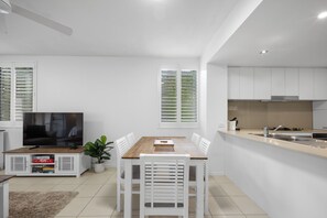 Enjoy a compact yet functional living space with a dining area, kitchen, and flat-screen TV.