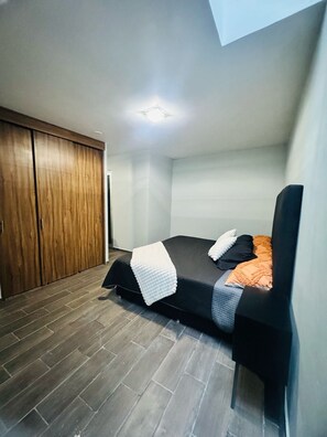Cozy retreat with a single bed, wooden wardrobe, and modern design.