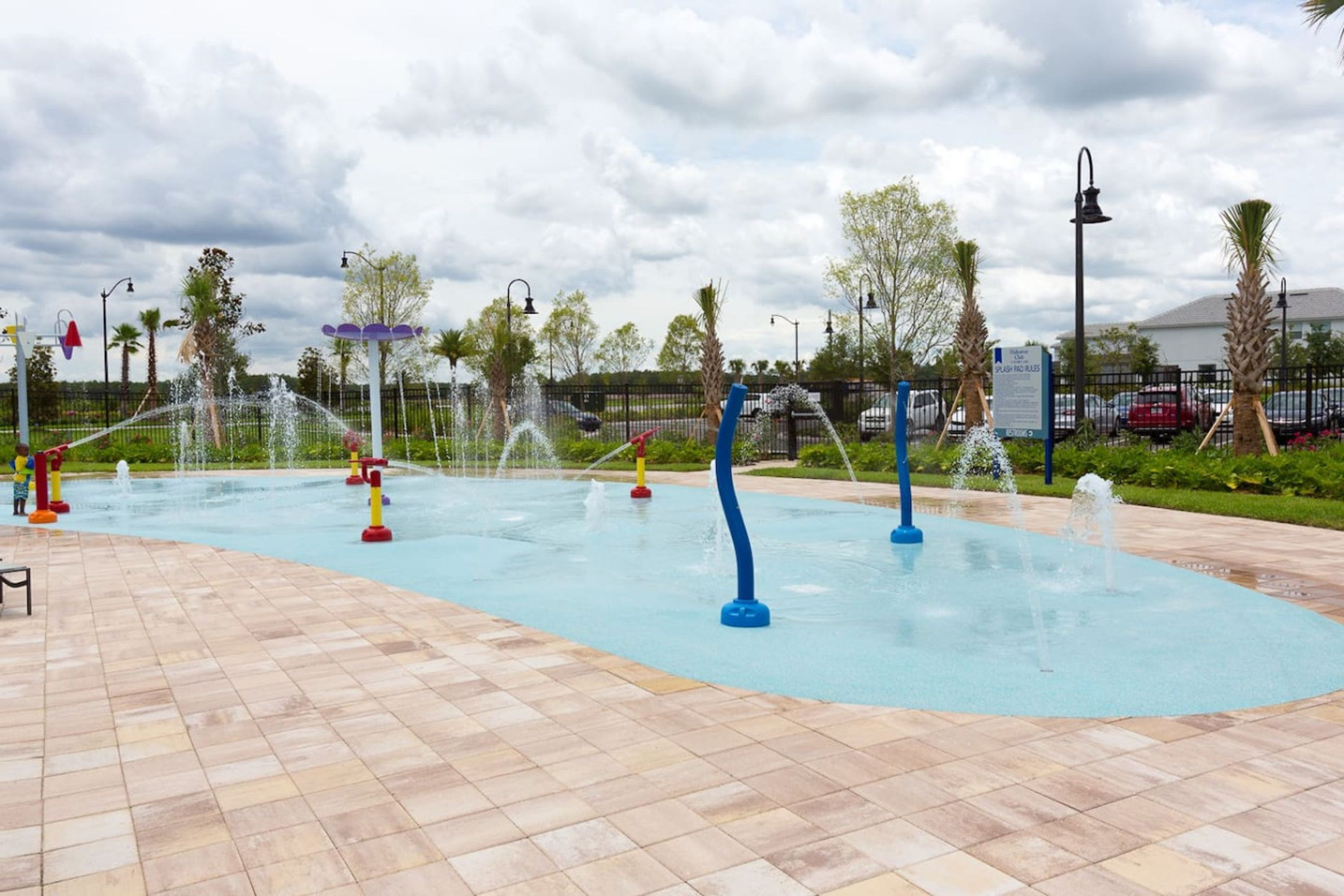 A water play area with multiple fountains and a tiled floor.