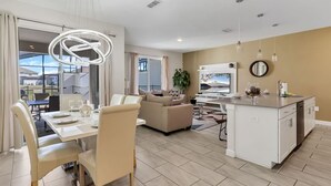 Una sala de estar moderna con comedor, cocina y un balcón con vistas.