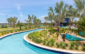 A pool area with palm trees, a water slide, and lounge chairs. - Your 5bdr House w Pool - 4959 (Kissimmee)
