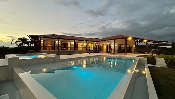 A modern house with a swimming pool, a covered patio, and a well-lit exterior at dusk. - U-GO Toledo 78 (Montenegro)