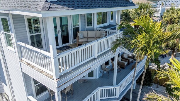 A two-story house with a balcony, a porch, and a patio area. - Welcome to Bluefin – Your Waterfront Getaway! (Treasure Island)
