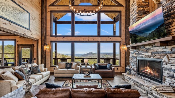 Un salón amplio con chimenea de piedra, ventanas grandes y techo alto.
