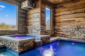 Relax in a serene hot tub surrounded by a tranquil pool area and stunning natural views.