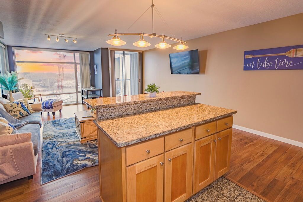 A modern kitchen with granite countertops, wooden cabinets, and a built-in island.