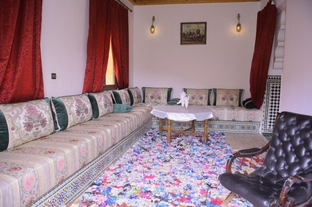 Ein Wohnzimmer mit einer Sofagarnitur, einem Tisch und einem Sessel.