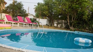 A swimming pool with a tiled edge, a pool ladder, and a floating ring. - Cool Villa Guest House (Sekondi-Takoradi)