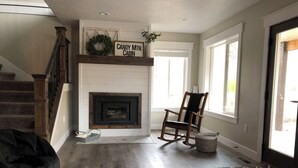 A living room with a fireplace, a rocking chair, and a staircase.