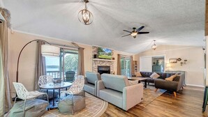 A spacious living area with a fireplace, comfortable seating, and a view of the outdoors. - Kelly Kove - Beach Area Sleeps 14, Private Dock, Pet Friendly (Penhook)