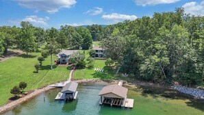 A lakeside property with a dock, a small boat house, and a covered area. - Kelly Kove - Beach Area Sleeps 14, Private Dock, Pet Friendly (Penhook)