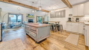 A spacious kitchen with wooden beams, a large island, and white cabinetry. - Kelly Kove - Beach Area Sleeps 14, Private Dock, Pet Friendly (Penhook)