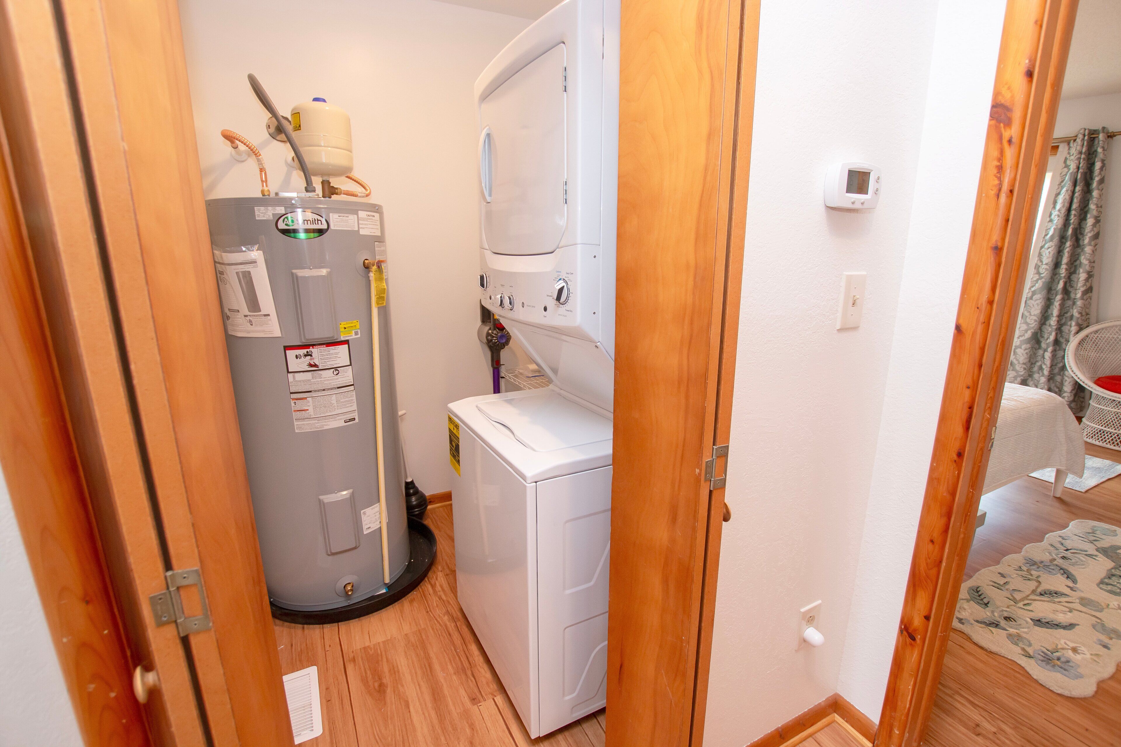 A laundry room with a water heater, a washing machine, and a dryer.