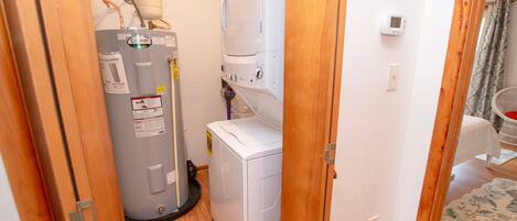 A laundry room with a water heater, a washing machine, and a dryer.