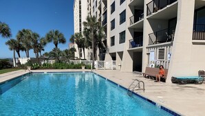 A swimming pool with clear blue water, surrounded by a white fence and palm trees. - WELCOME TO THE IVORY TOWER AT ARCADIAIN SHORES - 2 BEDROOM - CONDO ON THE OCEAN (Myrtle Beach)