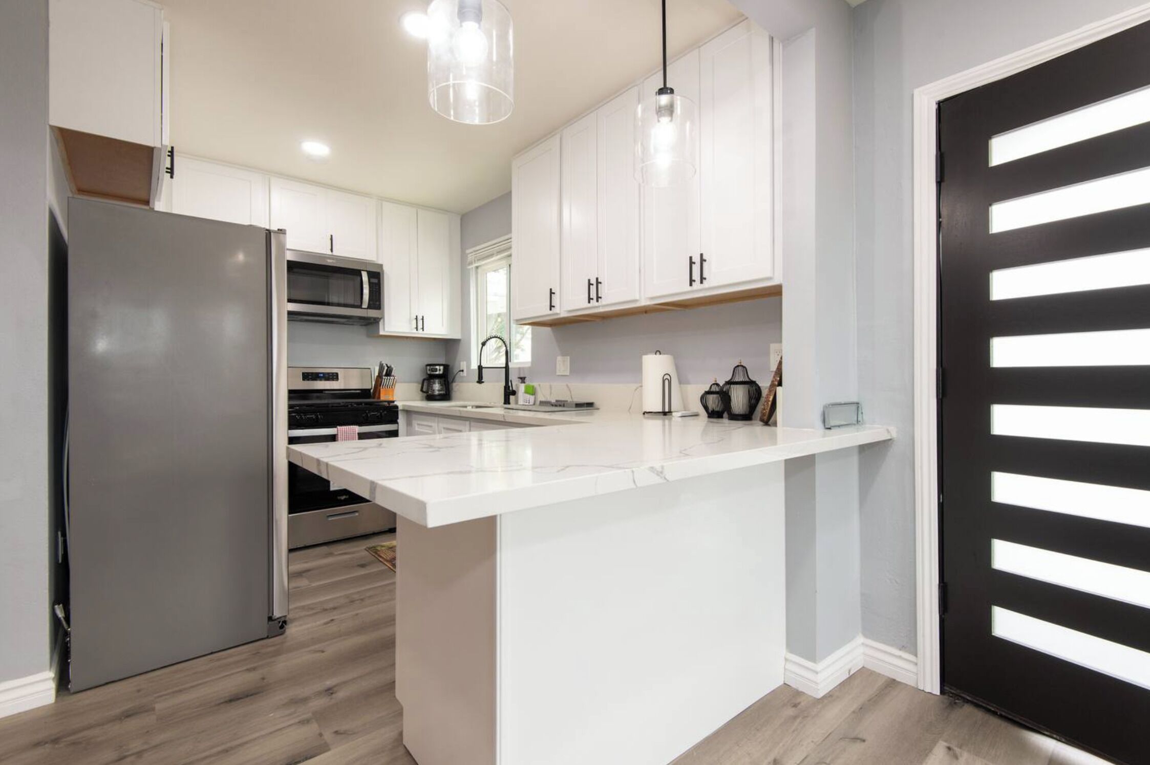 Una cocina moderna con armarios blancos, electrodomésticos de acero inoxidable y una isla grande.