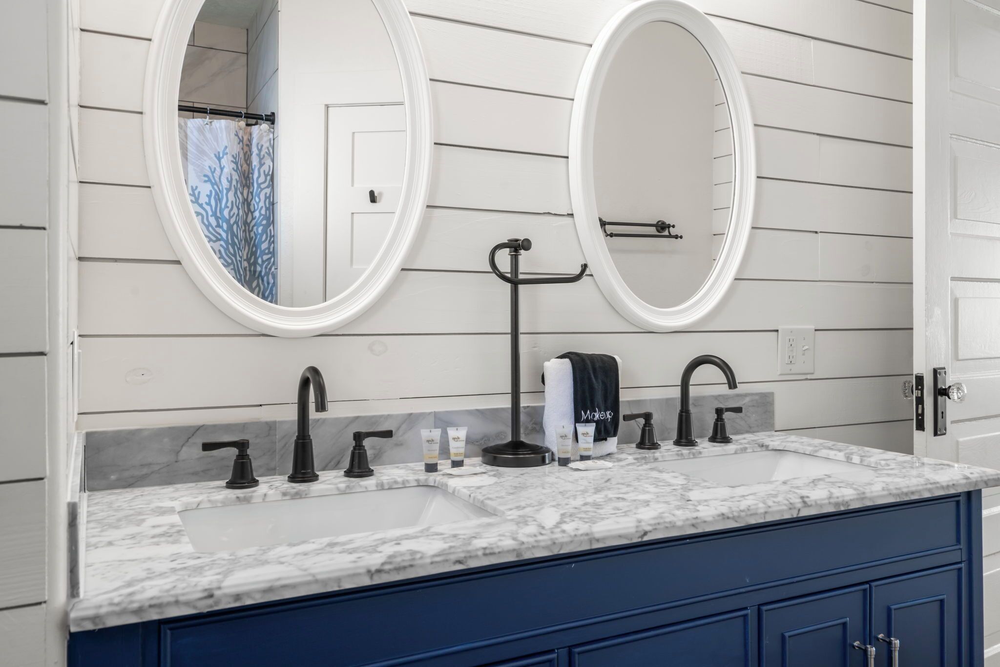 Une salle de bain avec deux lavabos, un porte-serviettes et un miroir.