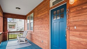 Ein Holzhaus mit einer blauen Tür und der Hausnummer 2115.