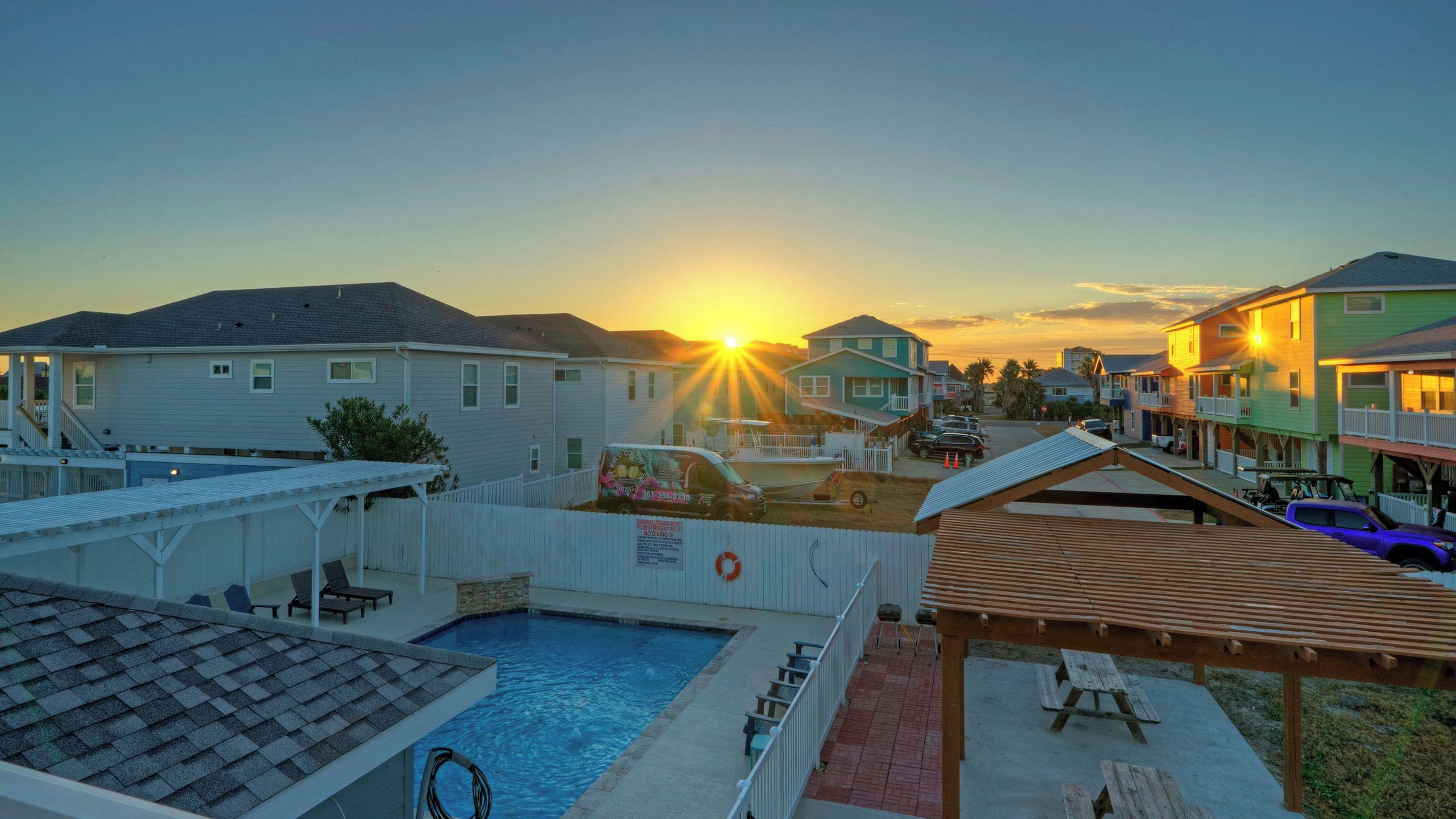 A residential area with houses, a swimming pool, and a covered patio area.