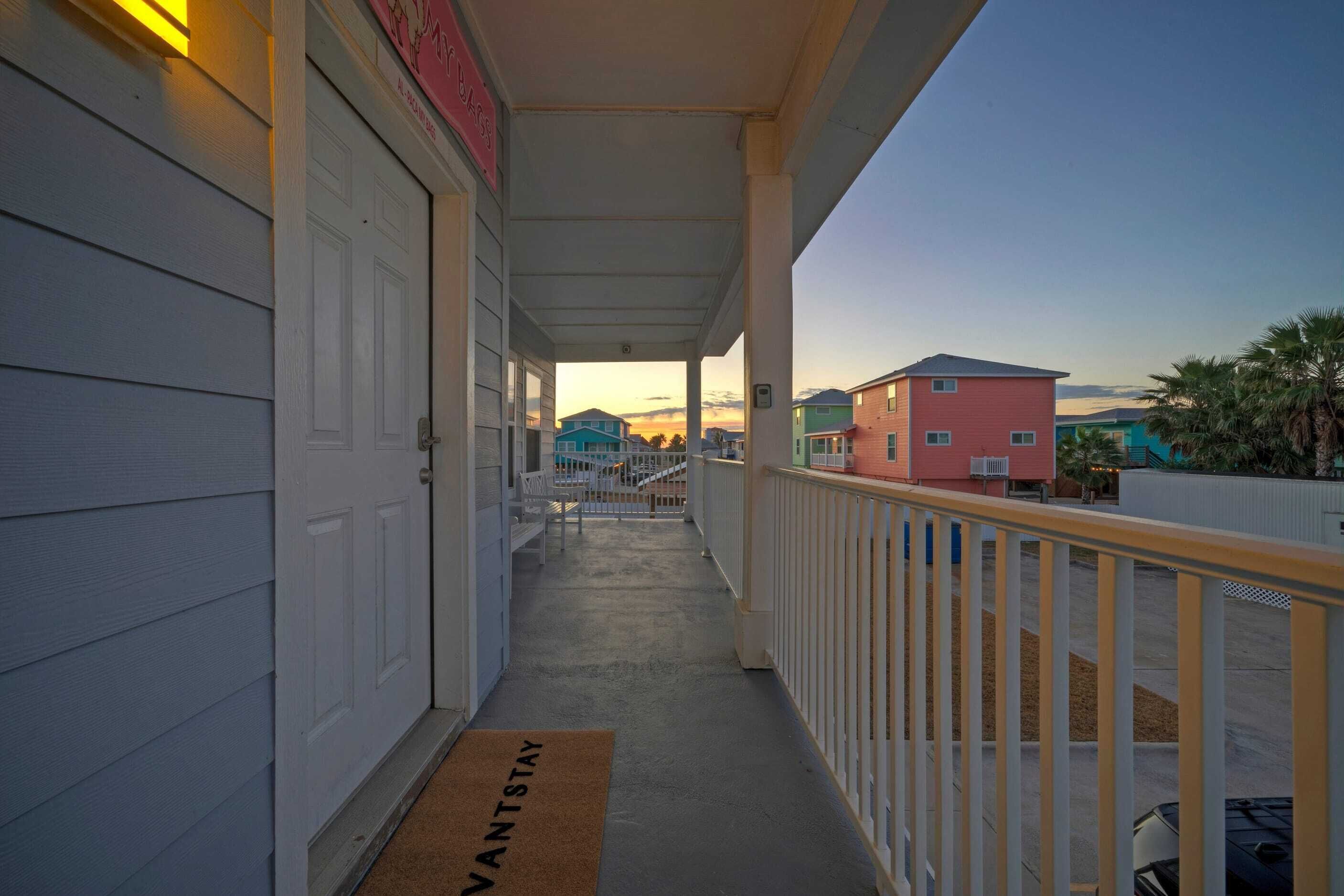 A covered porch with a doormat reading "VANTSTAY" leading to a white door.