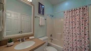 Une salle de bain avec un lavabo, des toilettes et une baignoire.