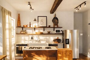 Una cucina moderna con isola centrale, elettrodomestici integrati e dettagli in legno.