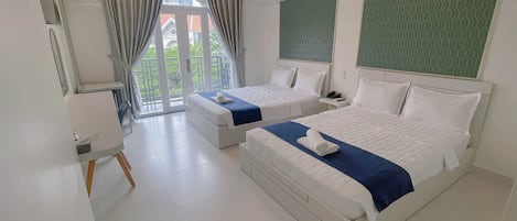 A hotel room with two beds, a balcony, and a large window.
