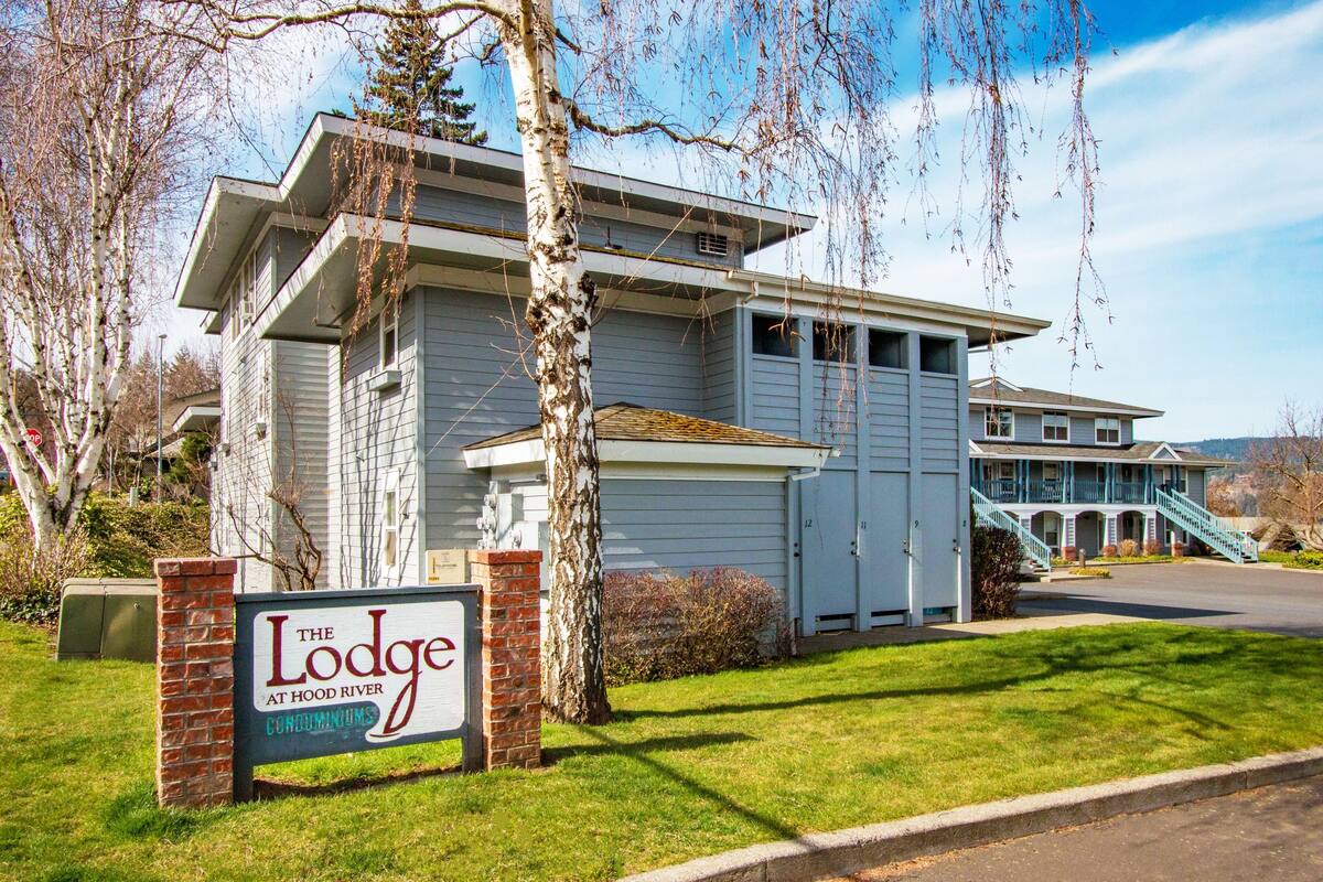 A two-story building with a sign indicating it is "The Lodge at Hood River Condominiums."