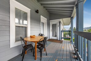 A covered porch with a wooden table and chairs, a door with a number, and a view of the outdoors. - Toro Bravo Condo 5 Minutes Drive To World Class Kitting And Windsurfing Beaches 1 Bedroom Condo (Hood River)