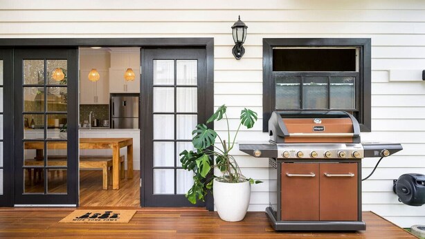 A modern kitchen with a large window, a built-in grill, and a potted plant. - Walking distance to train stations, sporting venues and parks (Hamilton)