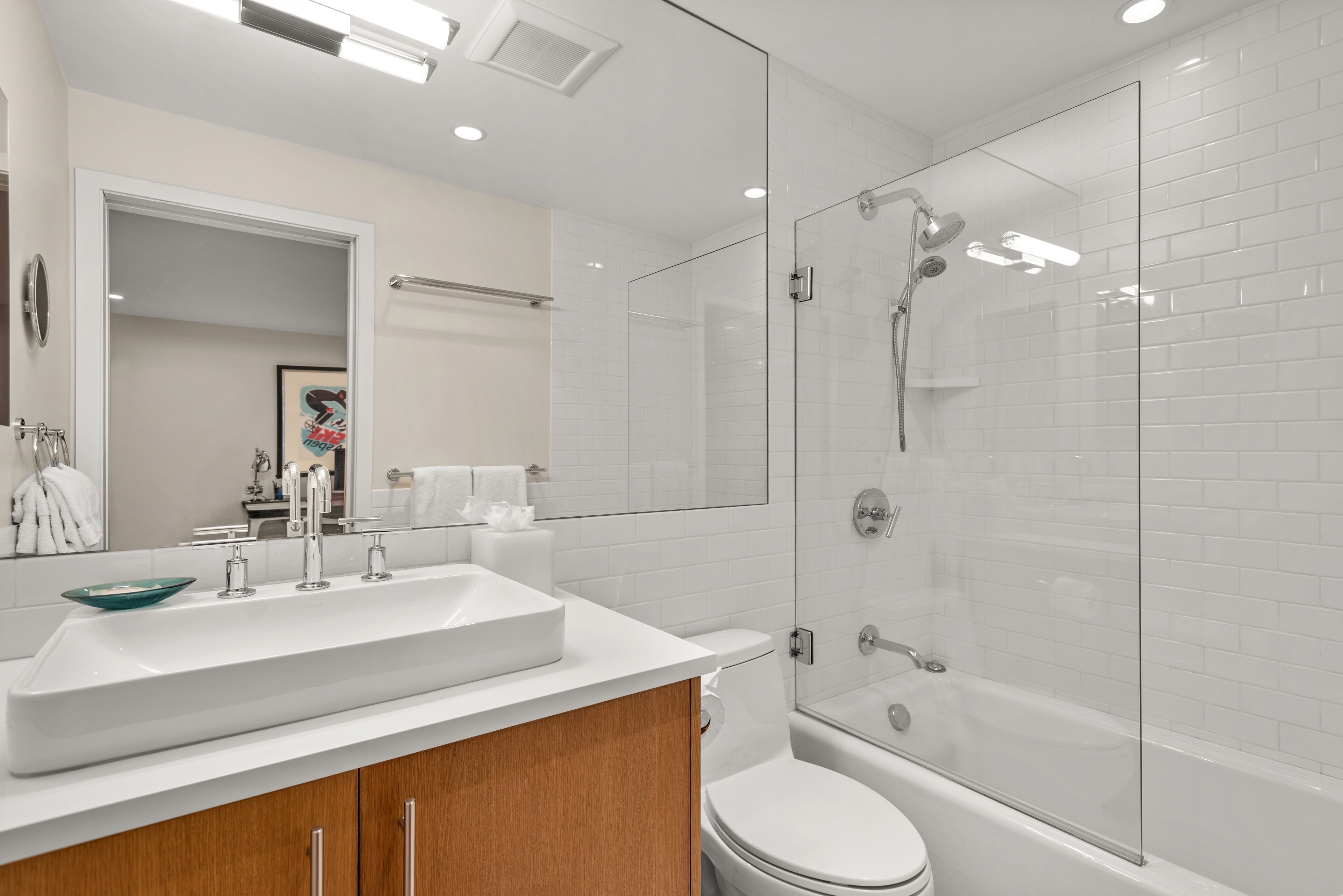Un baño moderno con un lavamanos grande, inodoro y ducha con cerramiento de vidrio.