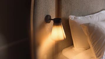 A wall-mounted lamp with a cylindrical shade illuminating a corner of a room.
