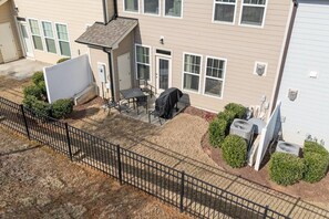 Un immeuble résidentiel doté d’un patio aménagé avec des meubles d’extérieur et un barbecue.
