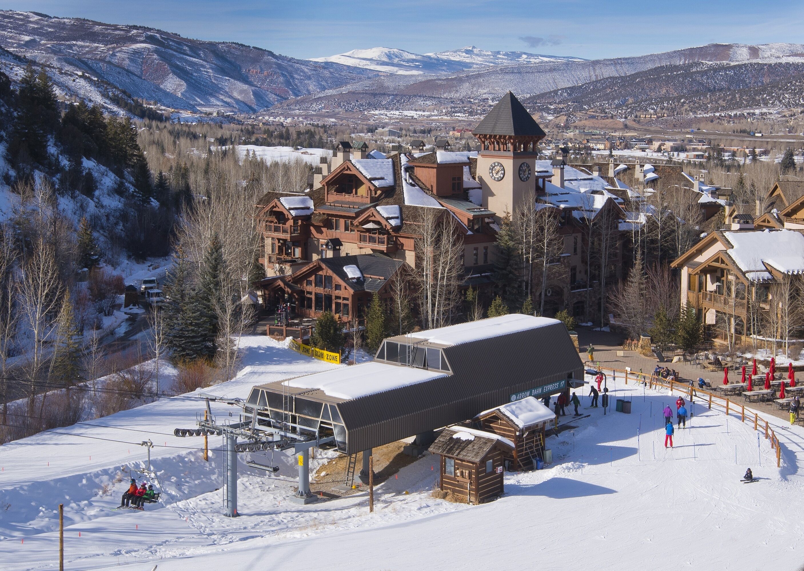A ski resort with wooden lodges, a ski lift, and a mountain backdrop.