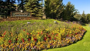 A sign for Arrowhead Country Club of the Rockies surrounded by a vibrant flower garden. - Edwards CO - Aspen Snowmasswood Lodge Vacation Rentals (Edwards)