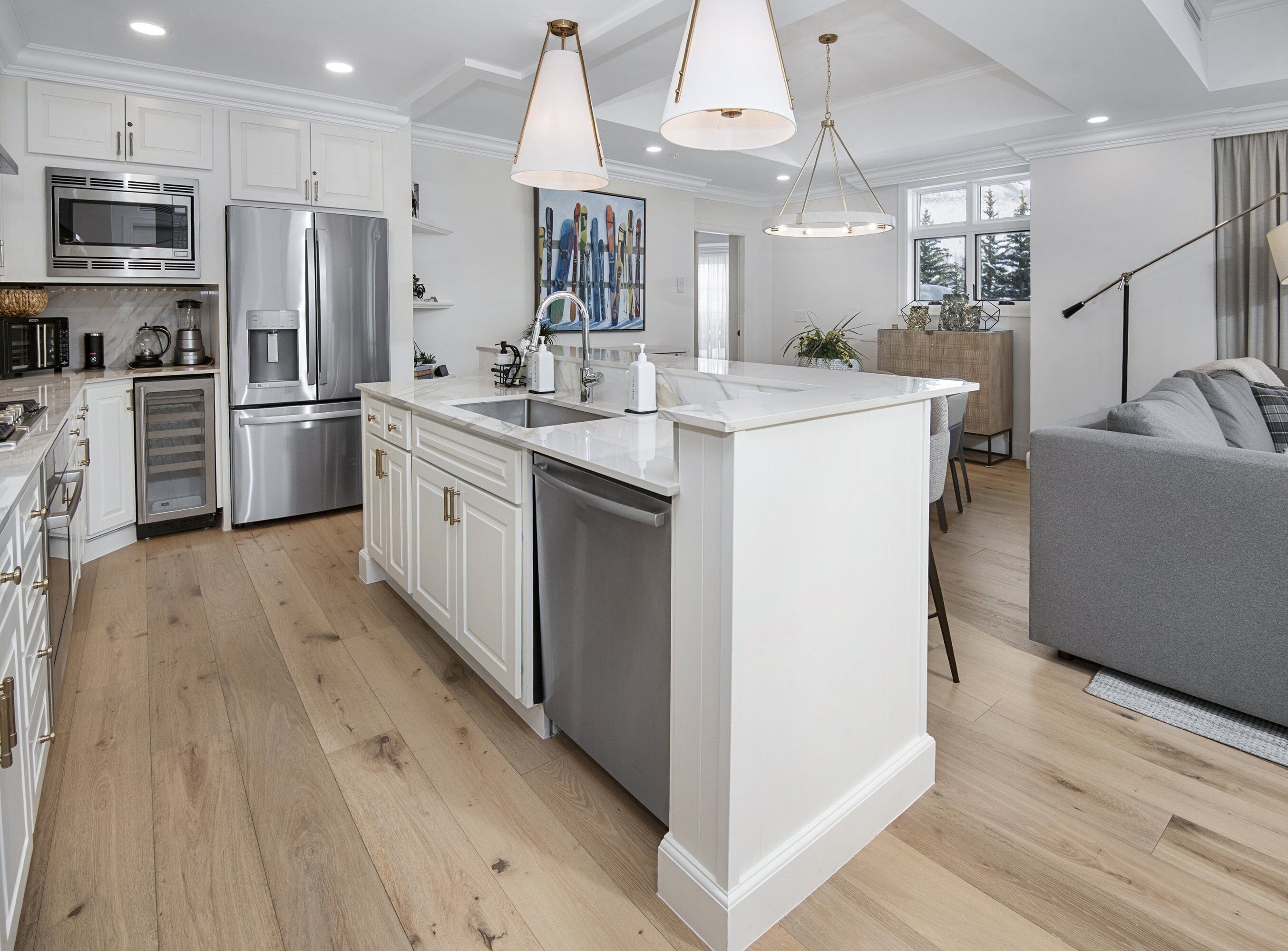 A modern kitchen with white cabinetry, stainless steel appliances, and a central island.