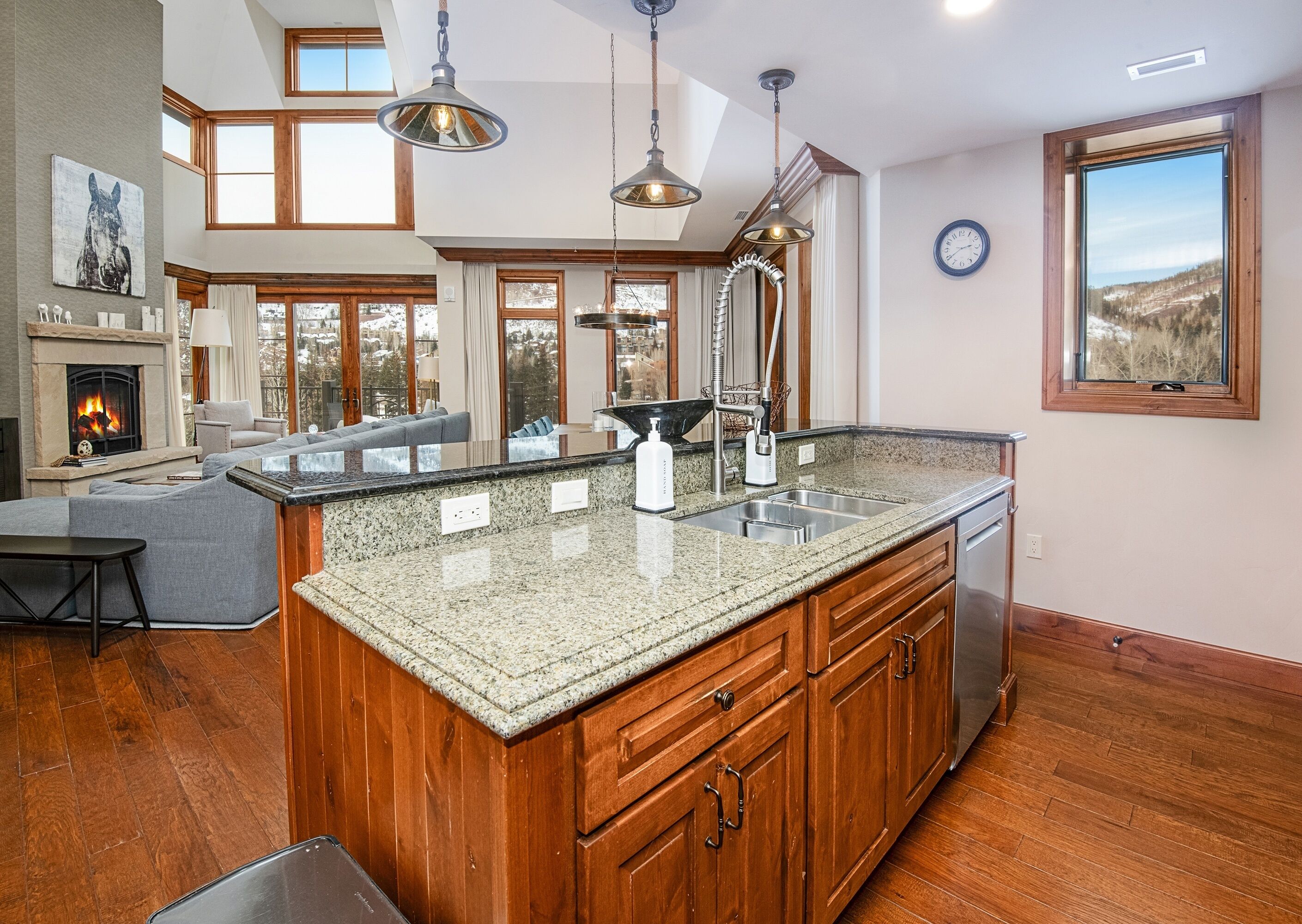 A spacious kitchen with a large island, wooden cabinets, and a built-in oven.