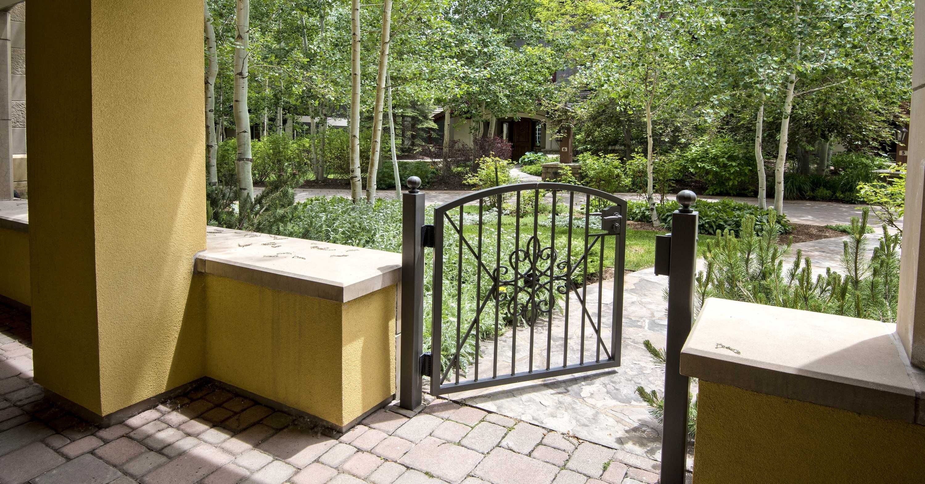 A gated outdoor area with a stone pathway leading to a building.