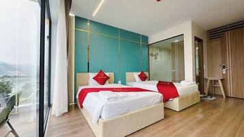 A modern hotel room with two beds, a balcony, and a view of the outdoors.