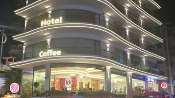 A multi-story hotel with a coffee shop on the ground floor.