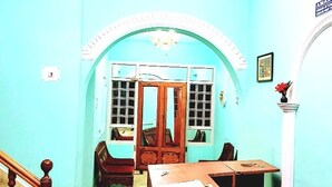 A room with a staircase, a wooden desk, a chair, and a door leading to another room. - aman palace hotel srinagar  (Srinagar)