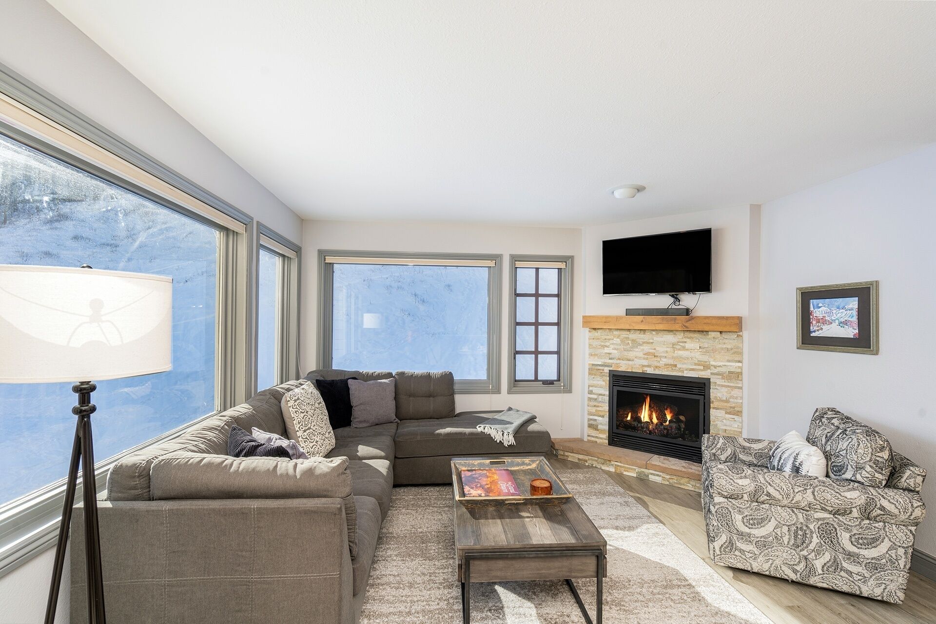 Ein Wohnzimmer mit Kamin, einer Couch, einem Couchtisch und einem Fernseher.
