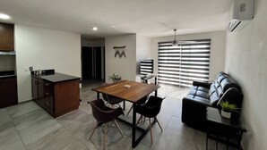 A modern living space with a dining area, kitchen, and seating area.