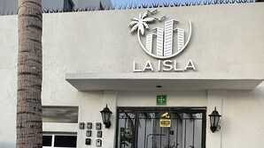 A building entrance with a sign reading "LAISLA" and a security camera above the door.