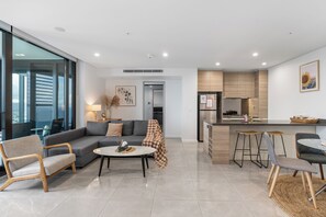 Un salon moderne avec un canapé, une table basse et des tabourets de bar.
